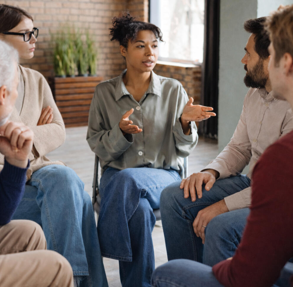 Mother sitting on a bed holding her baby while looking tired and overwhelmed during a difficult moment after childbirth