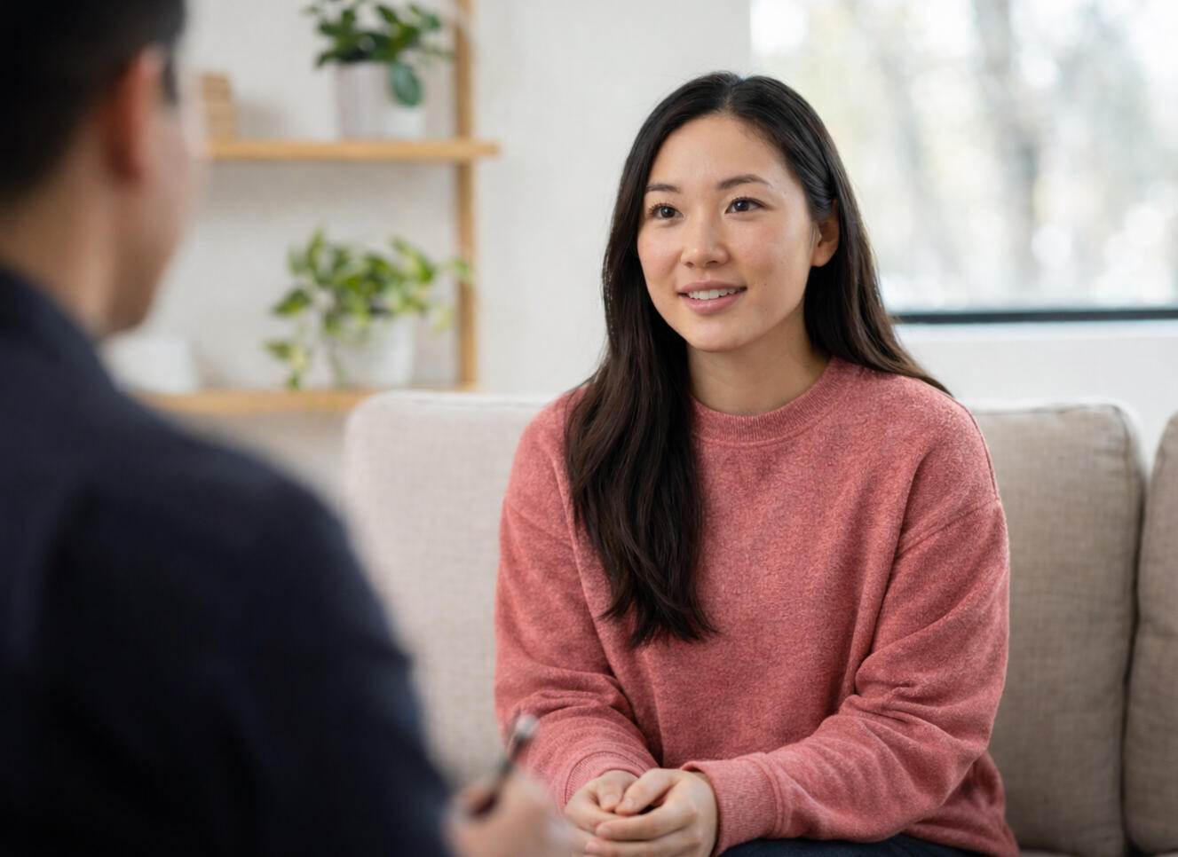 Mother sitting on a bed holding her baby while looking tired and overwhelmed during a difficult moment after childbirth
